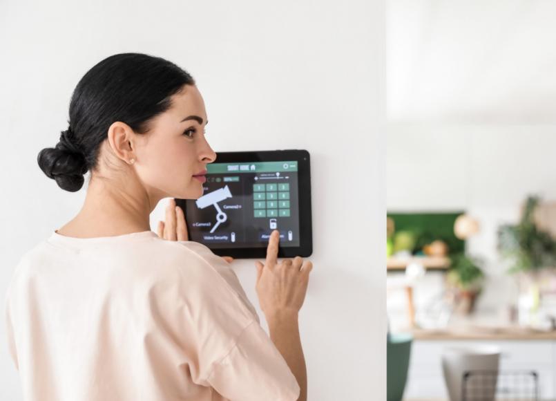 femeie care utilizeaza un panou de control acces pentru securitatea locuintei